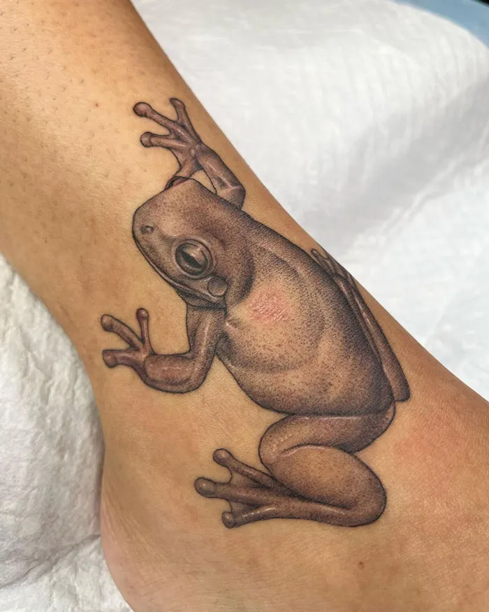 Realistic frog tattoo showcasing simplicity on skin, focusing on animal tattoo art.