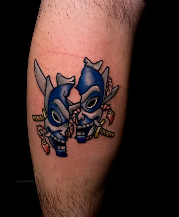 Blue mask calf tattoo design with sword accents, showcasing unique and cool tattoo ideas.