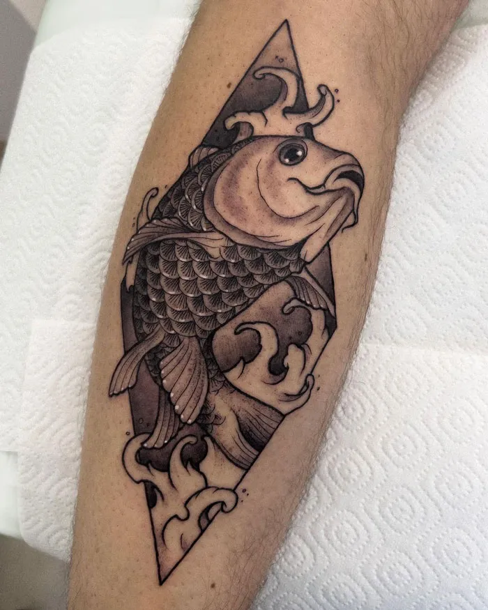 Lower leg tattoo of a stylized koi fish inside a diamond shape design.