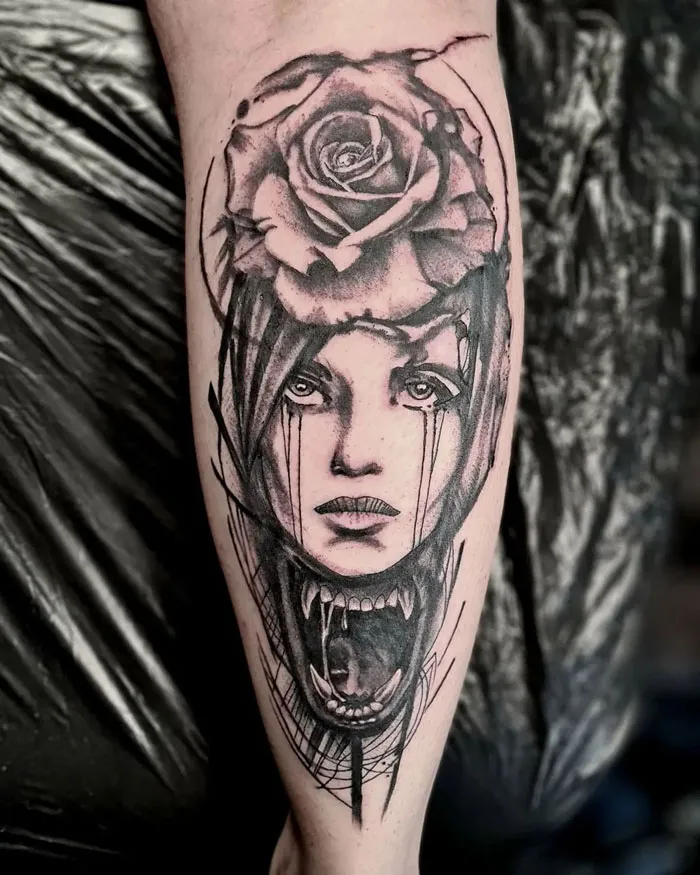 Calf tattoo featuring a surreal design with a rose and dramatic face illustration.