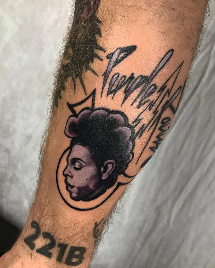Lower leg tattoo featuring a stylized portrait and bold text design.