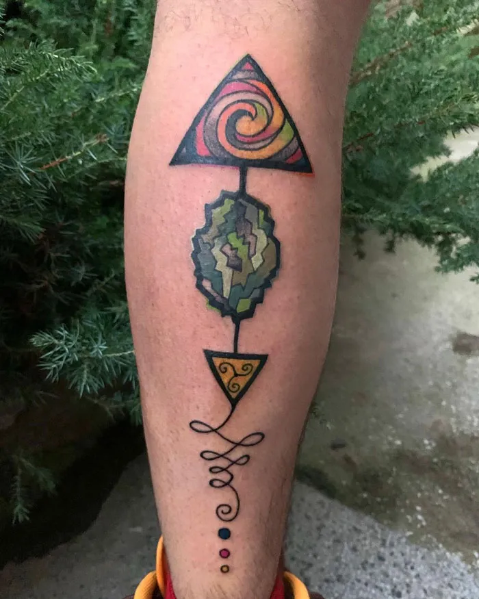 Abstract geometric calf tattoo design with vibrant colors.