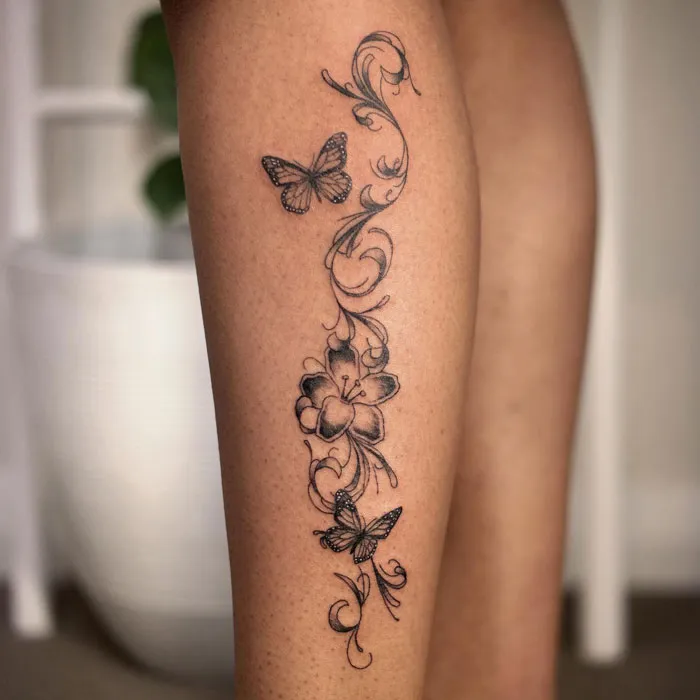 Floral and butterfly calf tattoo design showcasing intricate details and coolness.