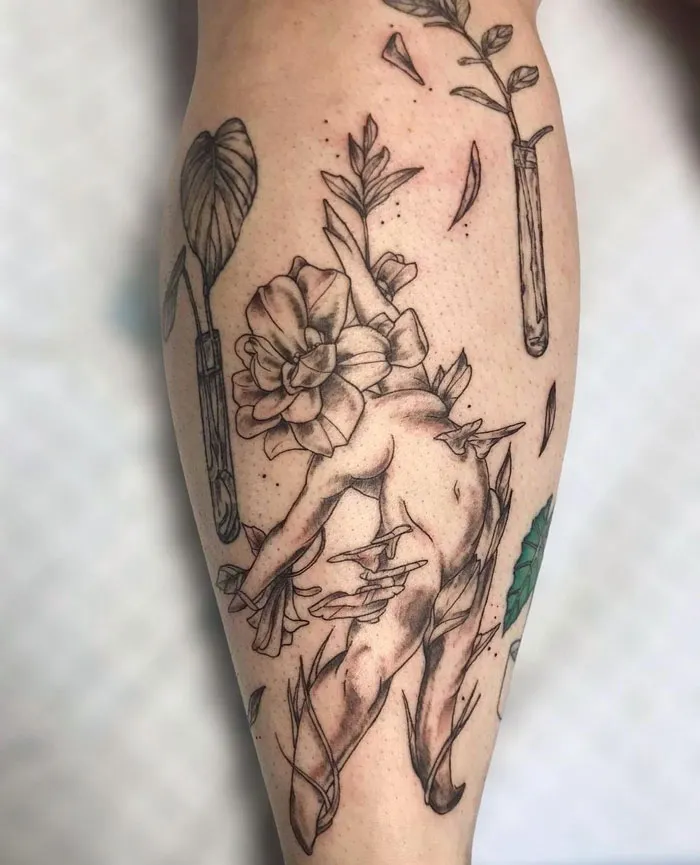 Calf tattoo featuring a cherub entwined with flowers and leaves in a unique artistic design.