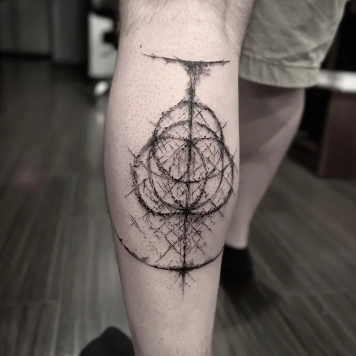 Geometric lower leg tattoo featuring abstract circular design in a minimalist style.