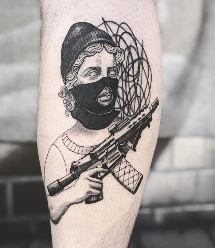 Tattoo of a masked figure with a rifle on a calf, showcasing unique calf tattoo ideas.