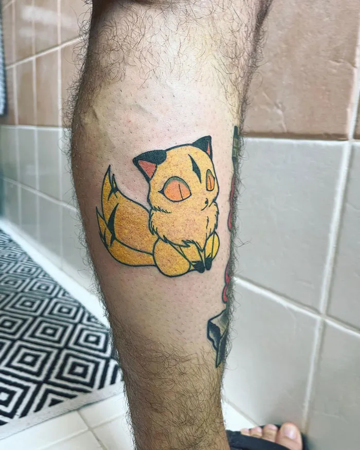 Lower leg tattoo featuring a cartoon fox in a colorful design.