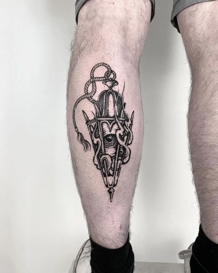 Artistic calf tattoo featuring intricate black ink tribal design.