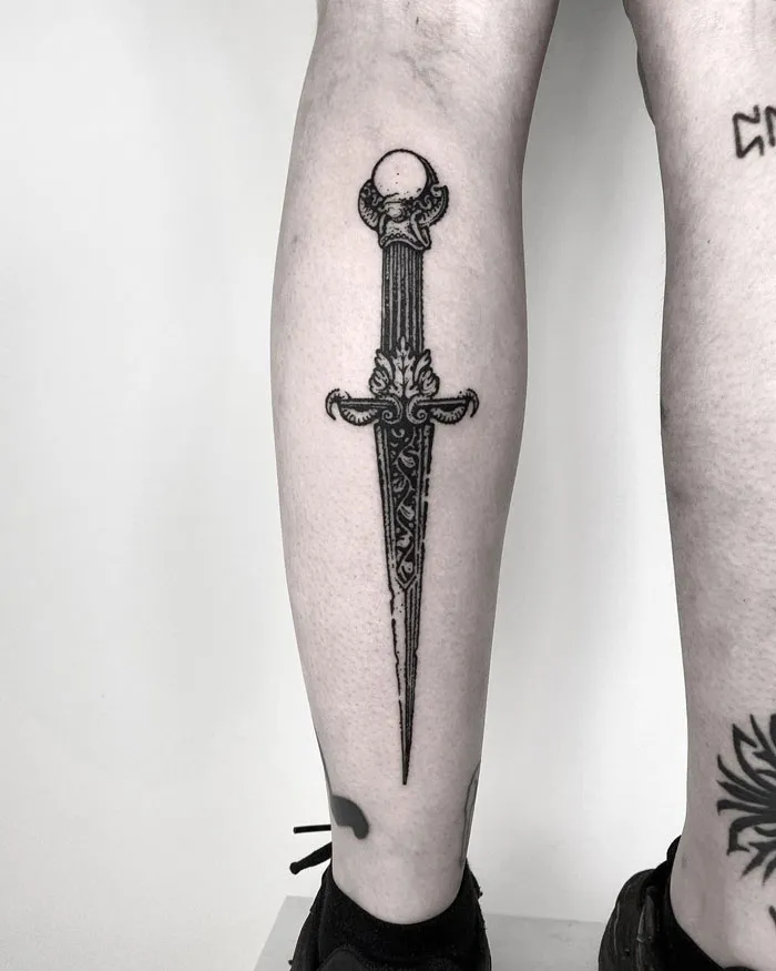 Ornate sword design tattoo on lower leg, showcasing one of the many awesome lower leg tattoos available online.