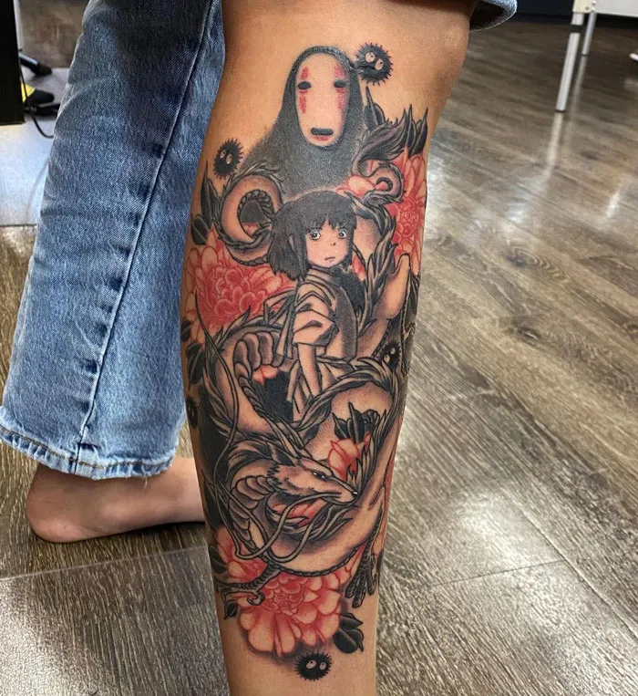 Lower leg tattoo featuring detailed anime characters with floral accents.