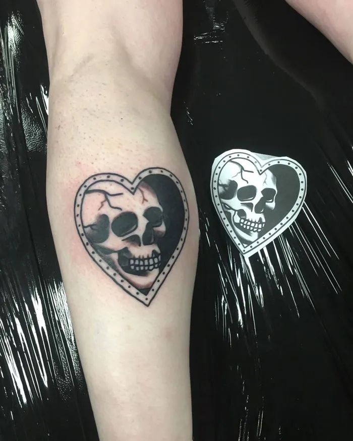 Heart-shaped skull tattoo on lower leg, showcasing unique lower leg tattoo design.