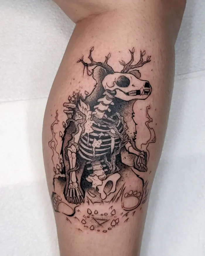 Skeleton bear lower leg tattoo with antler details, showcasing intricate and dark design elements.