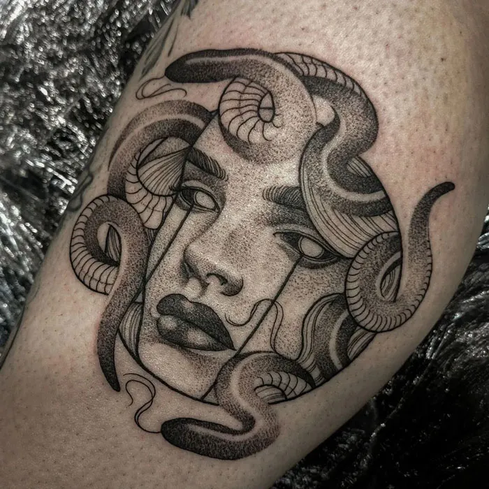 Calf tattoo featuring an intricate face with snakes, showcasing cool and unique tattoo design ideas.
