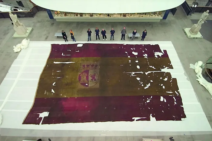 El tamaño de esta bandera ondeada en un barco español en la batalla de Trafalgar (1805) comparado con el tamaño de la gente que la rodea