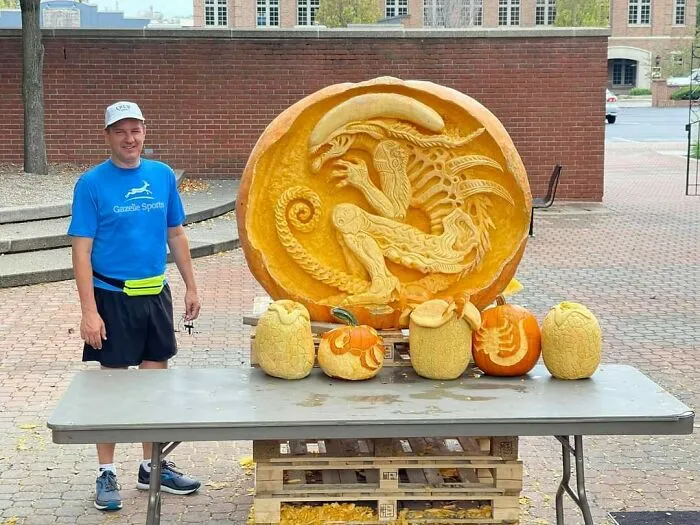 Mi papá junto a una calabaza tallada en un concurso en mi ciudad
