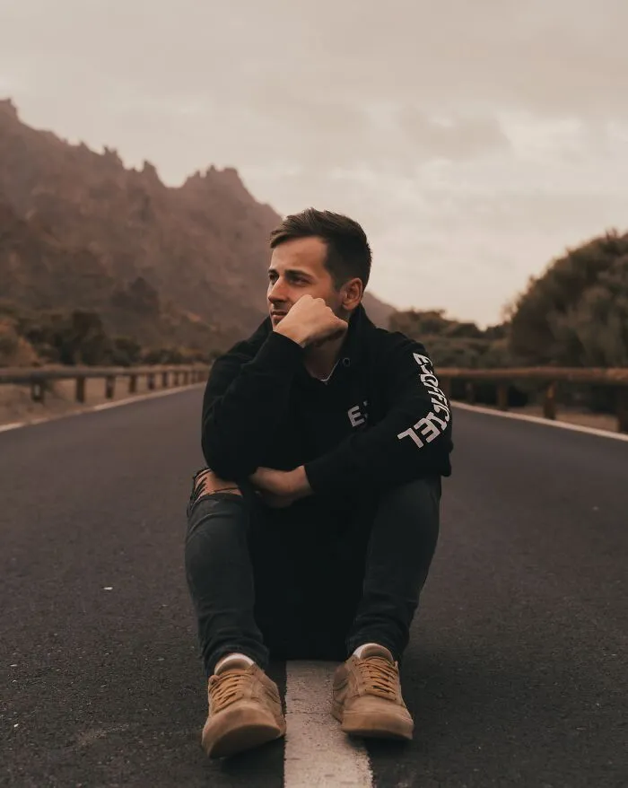 Man sitting on the road and thinking