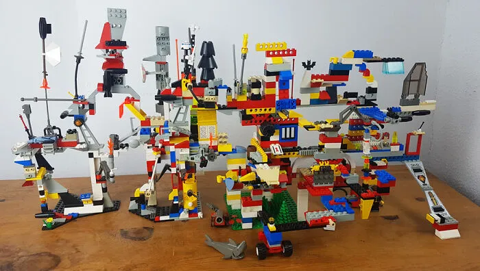 Colorful and intricate LEGO builds arranged on a wooden table showcasing incredible creativity and detail in art form.
