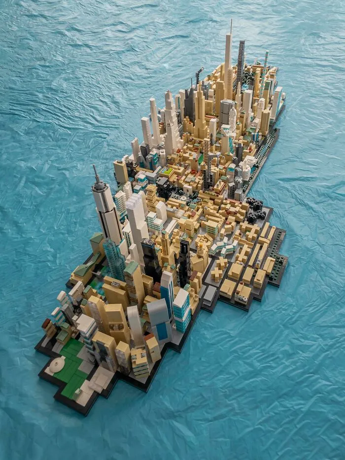 Intricate LEGO builds forming a detailed cityscape model on a blue surface showcasing creative architectural art.