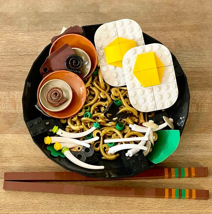 Intricate LEGO builds of a food dish featuring eggs, noodles, and chopsticks, showcasing incredible LEGO art craftsmanship.