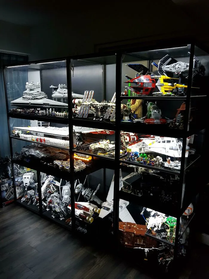 Display case filled with intricate LEGO builds featuring detailed Star Wars spaceships, showcasing incredible artistic skill.