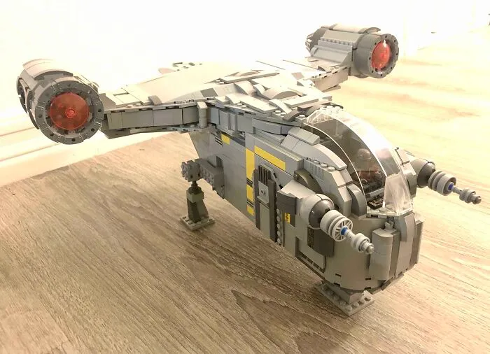 Detailed LEGO build of a futuristic aircraft displayed on a wooden surface, showcasing impressive LEGO art techniques.