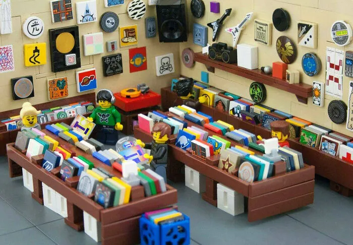 LEGO builds showcasing a detailed miniature record store with colorful vinyls and LEGO minifigures browsing the collection.
