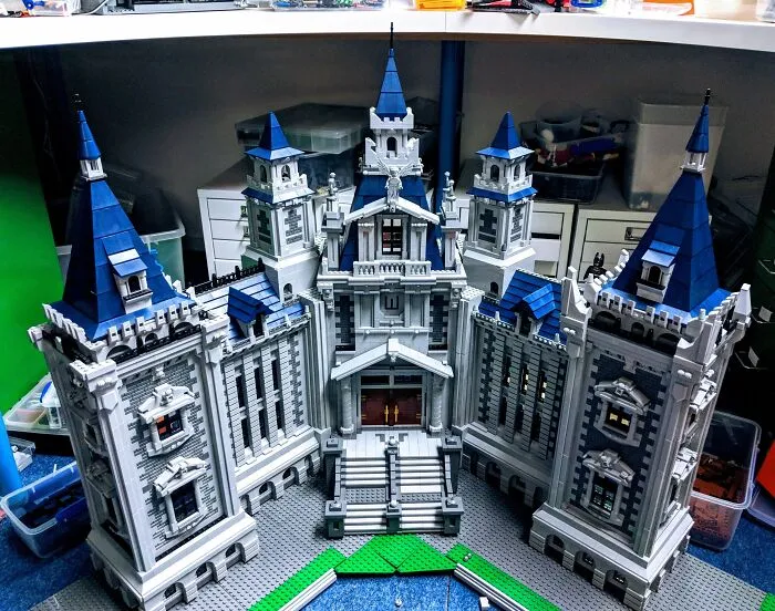 Intricate LEGO castle build with tall blue spires and detailed gray walls showcasing incredible LEGO art craftsmanship.