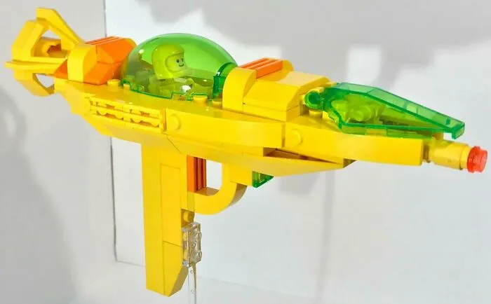 Yellow and green incredible LEGO build of a futuristic spaceship with a minifigure pilot inside cockpit.