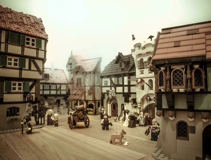 Incredible LEGO builds depicting a detailed medieval village scene with minifigures and intricate architecture.