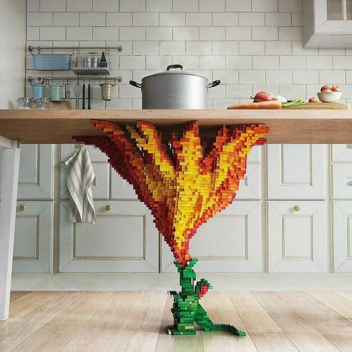 LEGO builds in a kitchen setting featuring a detailed fiery flame sculpture holding up a wooden table.