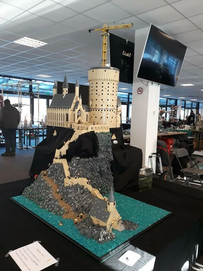 Detailed LEGO castle build on a rocky cliff surrounded by blue LEGO water, showcasing incredible LEGO builds as art.