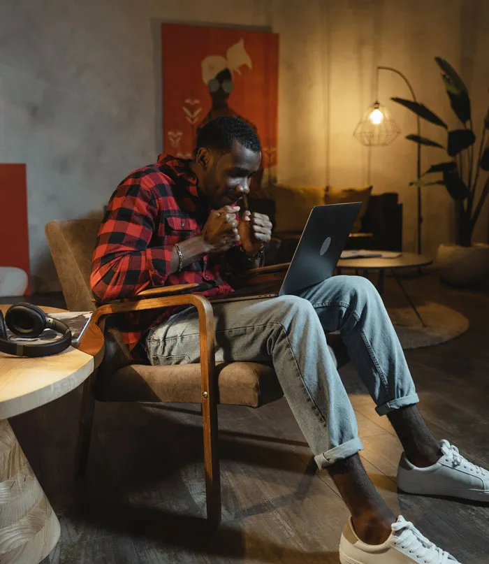 Man in a cozy setting enjoying laptop activities to avoid boredom at home.