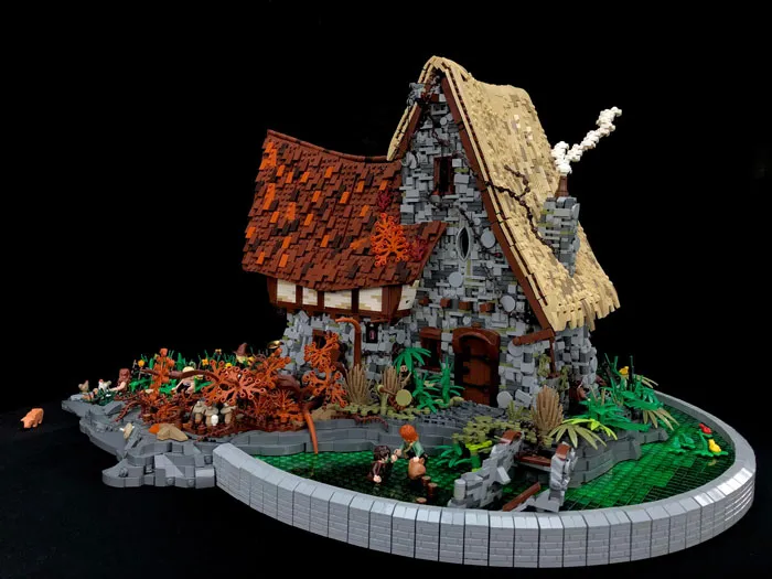 Intricate LEGO build of a stone cottage with detailed roof and garden showcasing incredible LEGO art skills.