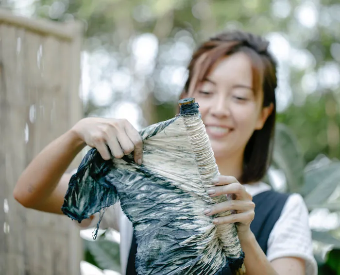 Woman enjoying a fun at-home activity by dyeing fabric outdoors.
