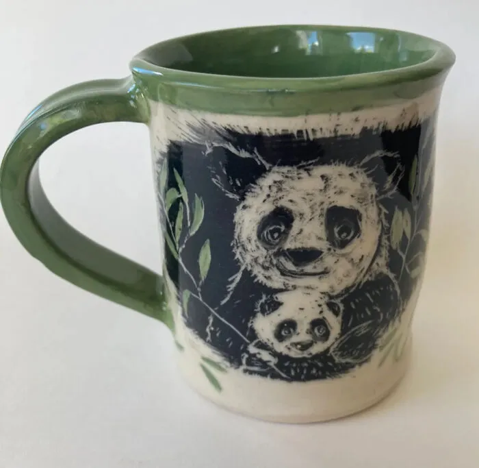 A Panda And Her Cub Munch Contentedly On Bamboo Leaves