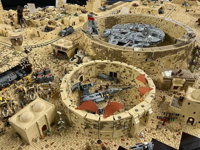 LEGO builds of a detailed desert sci-fi scene featuring round structures, vehicles, and miniature figures in a sandy environment.