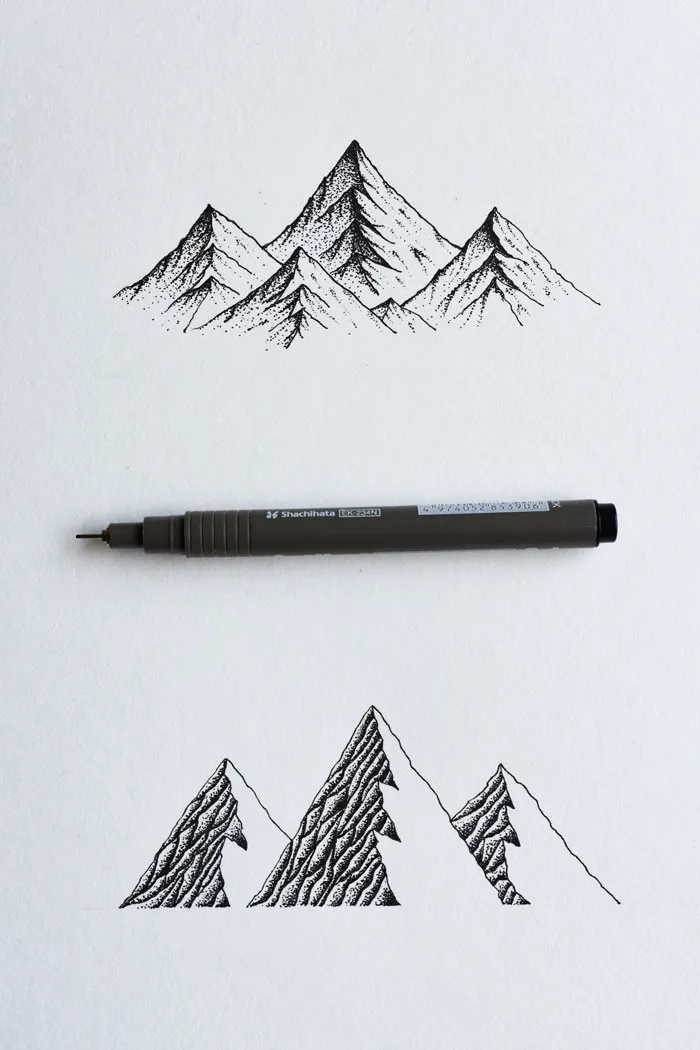 Black pen drawing of mountain peaks on white paper, showing creative drawing prompts.