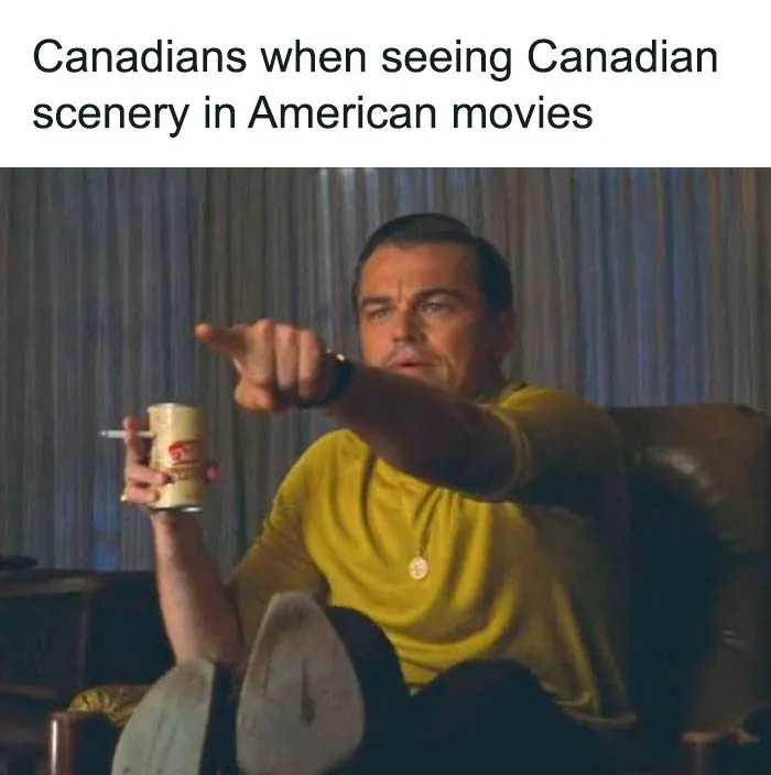 Man in a yellow shirt pointing at a TV, embodying Canadian humor about Canadian scenery in films.