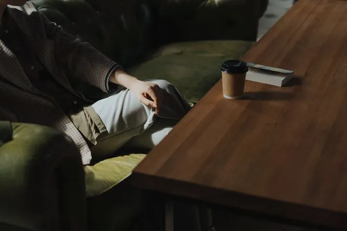 Woman Sitting In Dark Room Drinking Coffee 