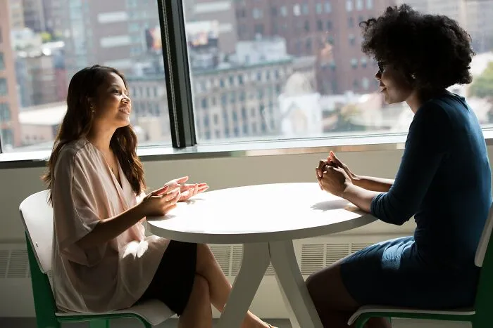 Two Girls Talking Inside On A Sunny Day 