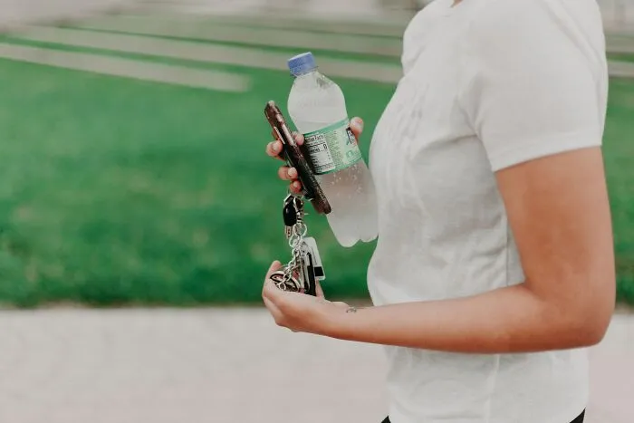 Person Walking And Carrying Water Keys And Mobile Phone 