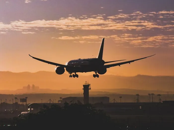 Plane Landing While The Sun Is Setting 