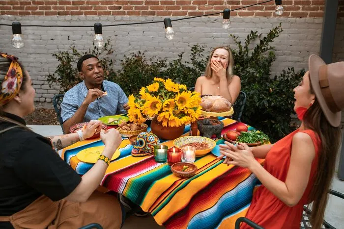 Friend Group Laughing At The Dinner Table 