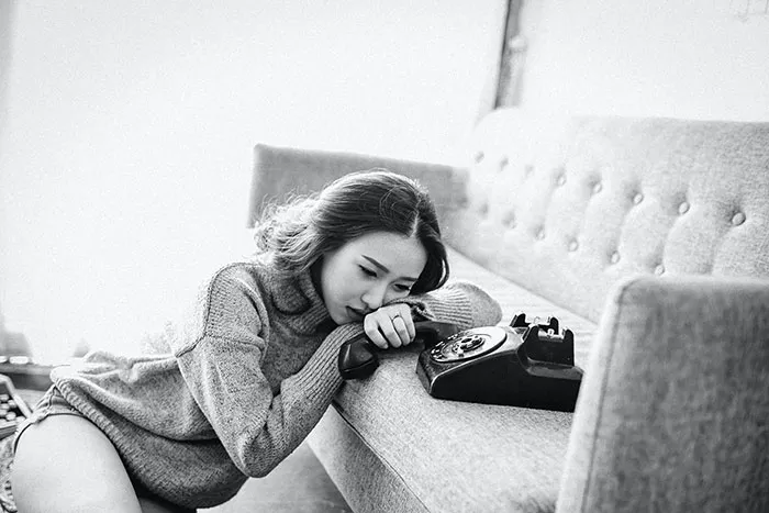 Woman lying on the sofa and holding phone