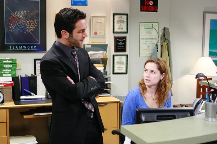 Two coworkers in an office showing signs of tension, illustrating fake friend and toxic relationship behaviors.