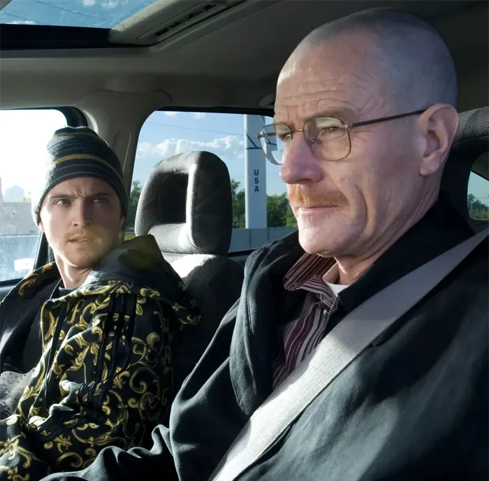 Two men in a car showing signs of a fake friend and a toxic relationship through tense expressions and body language.
