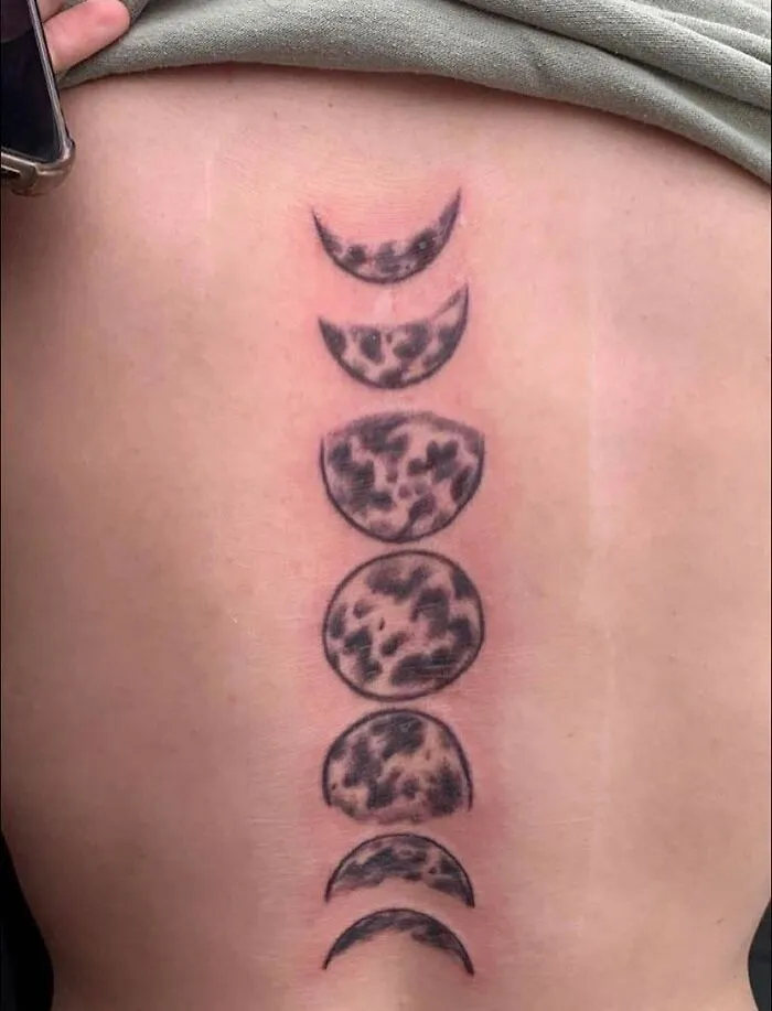 Phases of the moon tattoo on skin, part of a collection of poorly done tattoos from a Facebook group.