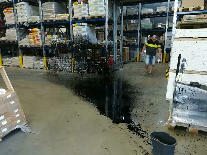 Un compañero de trabajo condujo una carretilla elevadora sobre una lata de aceite