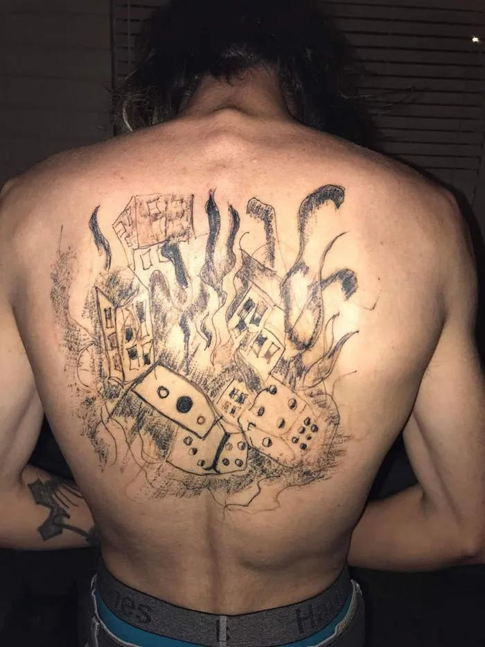 Bad tattoo of buildings and dominoes on a person's back, part of a humorous critique.