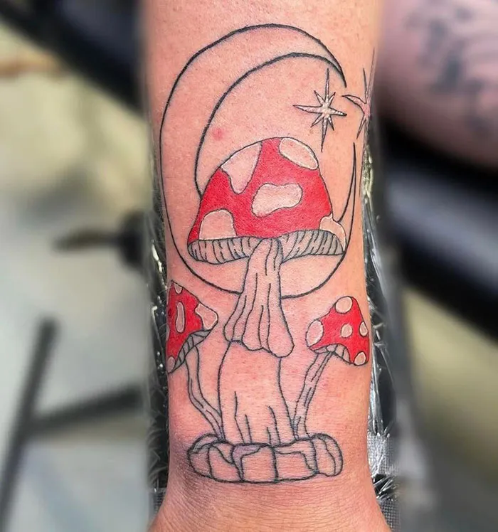 Tattoo of red mushrooms with crescent moon and stars; an example of bad tattoos shared online.